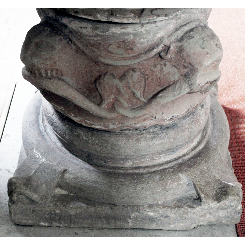 the bodies of the snakes thread their way above the lion heads; two ttails intertwined on the east side of the base