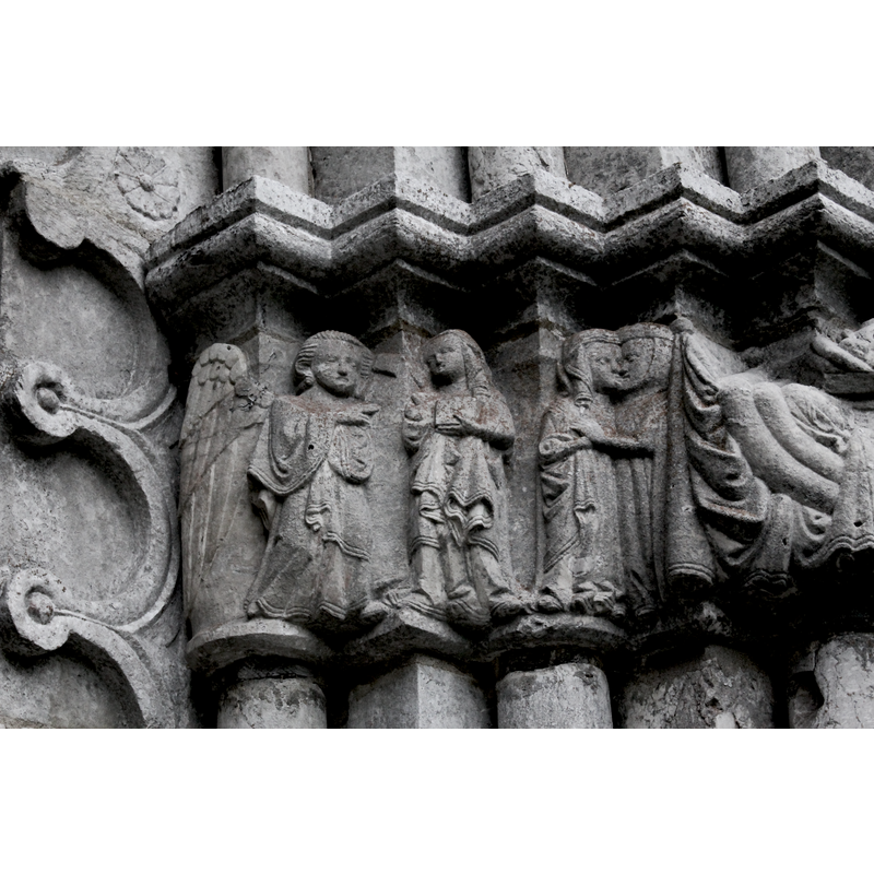 on the left Gabriel delivers his announcement to Mary, who is shown holding a book. On the right the two figures of the Visitation embrace and kiss