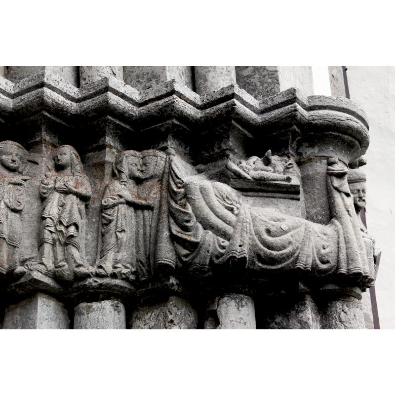 Annunciation and Visitation on the left. On the right, the large bed and its magnificent coverings dwarf Mary and the swathed Child in the manger lying rigidly with the heads of the ass and ox on it