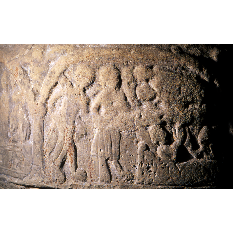 To the left a figure standing in 2/3 profiile, the right arm bent at elbow backwards and hand at thigh height - could be holding something - ? Bare legs appear and toes on the person's feet are articulated. To the right of that figure, 2/3 pose, wears a skirt to the knees, both feet are bare with toes evident. The right arm in the same position as the previous figure.  On the right half of the composition at the top, appears to be a bed, with two infants. Below this is a rectangular frame. In this is a scene of a woman reclining in a bed and a second figure to the far right, seated. Their hand point upward and palms open. There is no evidence of haloes. This may be an old testament scene - birth of Cain and Abel?