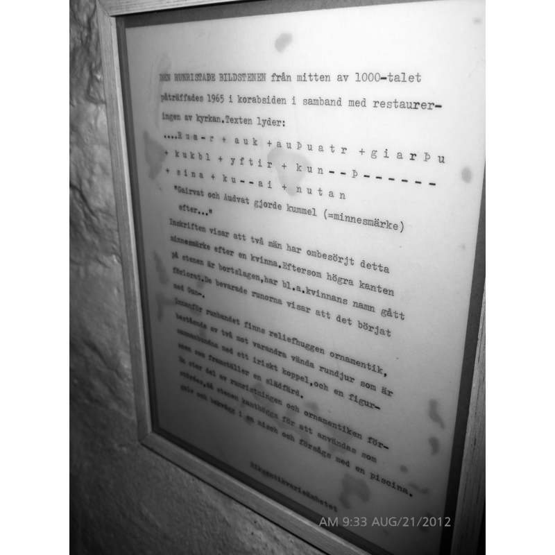 posted inside the church; dates the Runic stone to the mid-11th century, and notes that it was re-cycled as a piscina, hence the carved basin and drain hole
