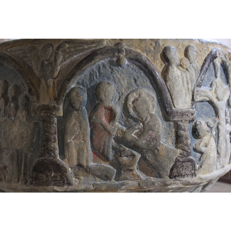 Christ washing the feet of his apostles. Three figures inside the arch; to the right sits Christ, cross-haloed; he holds the left leg of the figure sitting to his left with both hands; the seated figure has both arms crossed at the wrist, while his right leg rests on a chalice-shaped container. The figure on the left is sitting full frontal, arms to his chest; the feet appear to be resting on a curved object (a rainbow?) . In the spandrel two figures in profile, bearded, robed, a round object between their faces (another head? Loaf?)