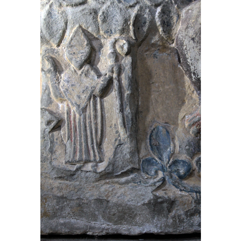 on the southeast side of the base [orientation is approximate] -- Figure of bishop standing, full frontal, immediately beneath the Visitation scene above; right hand raised in benediction, left hand holds a bishop staff