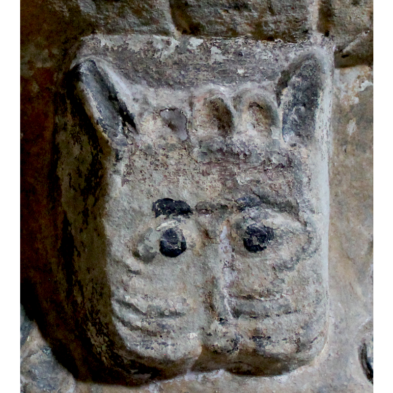 a mask-like rendering of a lion head on the southwest side of the base