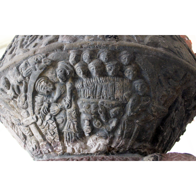 SCENE ON UNDERSIDE OF BOWL.  Across the top four faces, under them, a second row of four faces. Under that a bed with below that has showing stones. To the right is a figure holds a stone in left hand - the right hand is raised in benediction. To the right stand a figure in profile and the left hand clutches a sword point down. The right arm bent at elbow holds up an object - a stone? Were the previous two men, in spandrel holding loaves too? This would make 13 present. To the left a standing figure faces away from the scene(table) at the extreme left, two figures. The figure on the right, standing in profile, a large figure, holds the other figure on the left with both arms across the body.The figure to the left has the head down and appears in distress.IN THE SPANDREL - A figure lying down with hands bound is being torched or killed by a small figure with a lance or crowbar spearing out the eyes or head of bound person.