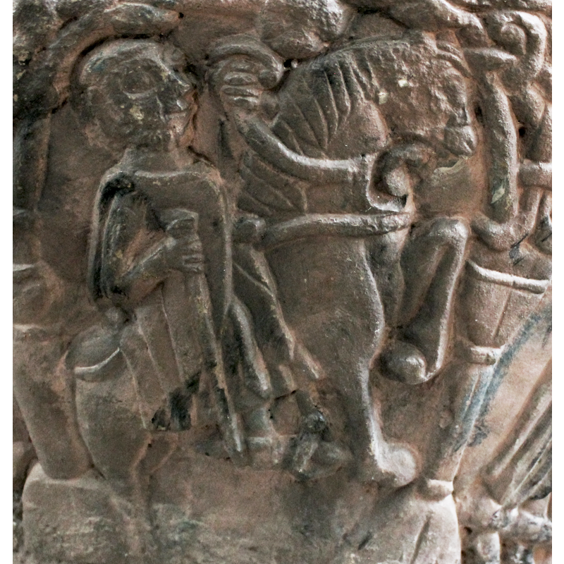 Mounted figure on horse. He wears no crown. He is bearded and holds a staff in his right hand. In his left hand is the bridle. He has spurs and stirrups. There may be a star.One of the wise man?