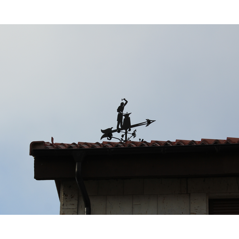 the weather-vane on the house next to the village church
