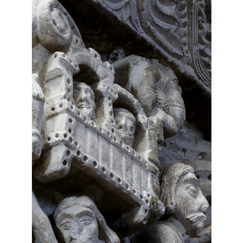 capital on the north side of the chancel arch: on the left side of the capital is a mounted male holding an object and/with a flowing cloth in the right hand; the left hand hold the bridle and a ring, or the ring is secured to the saddle; the horse tramples over a fallen bearded man who appears unarmed; the front side of the capital has a balcony with two males in it looking out; below the balcony a male figure leans on a short pillar (to which he may be tied?); the right side of the capital has a bearded man loading a stone into his sling, by the side of a mounted knight armed with a lance and a shield, and wearing a helmet; behind him is an unidentified beast