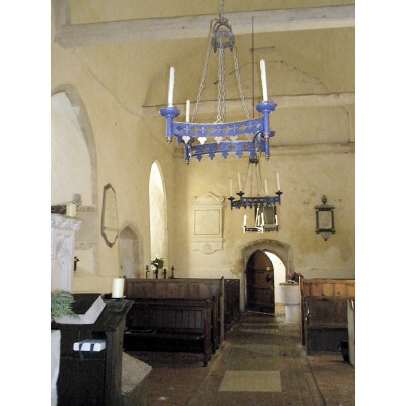 the font and cover at the back (west side), by the west doorway, on the right (north) side