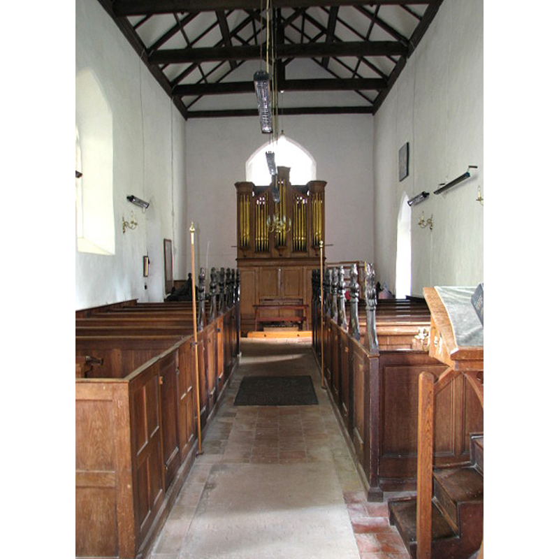 the font cover is partially visible at the back (west end), behind the left (south) bank of pews