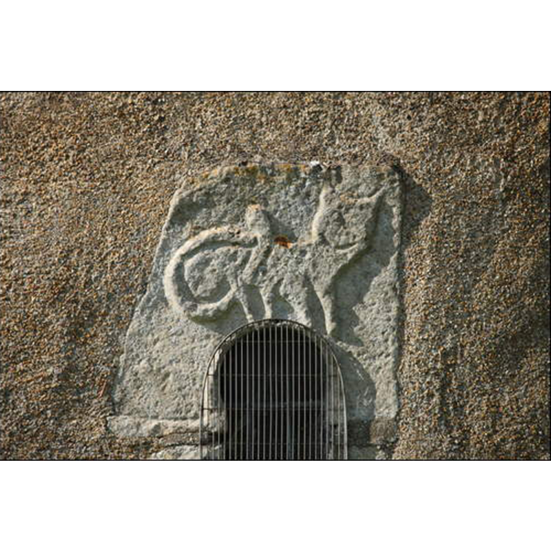 photo caption in The Digital Atlas of England: "On the south side outside a Saxon keyhole window with, above it, a relief carving of a cat"