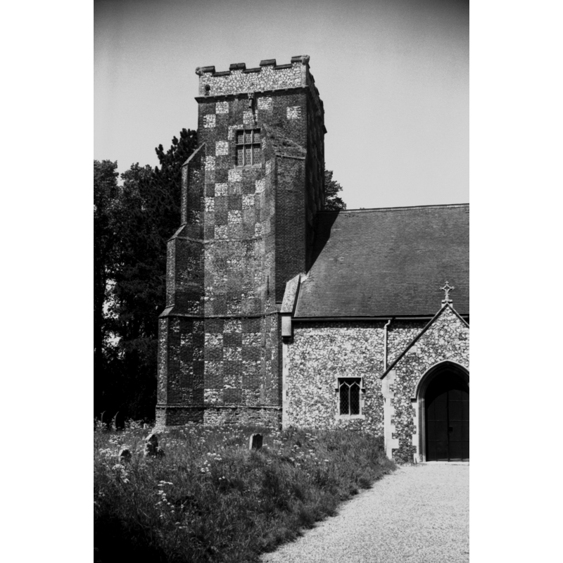 Photo caption: "16c tower with bold chequering in brick and flint"