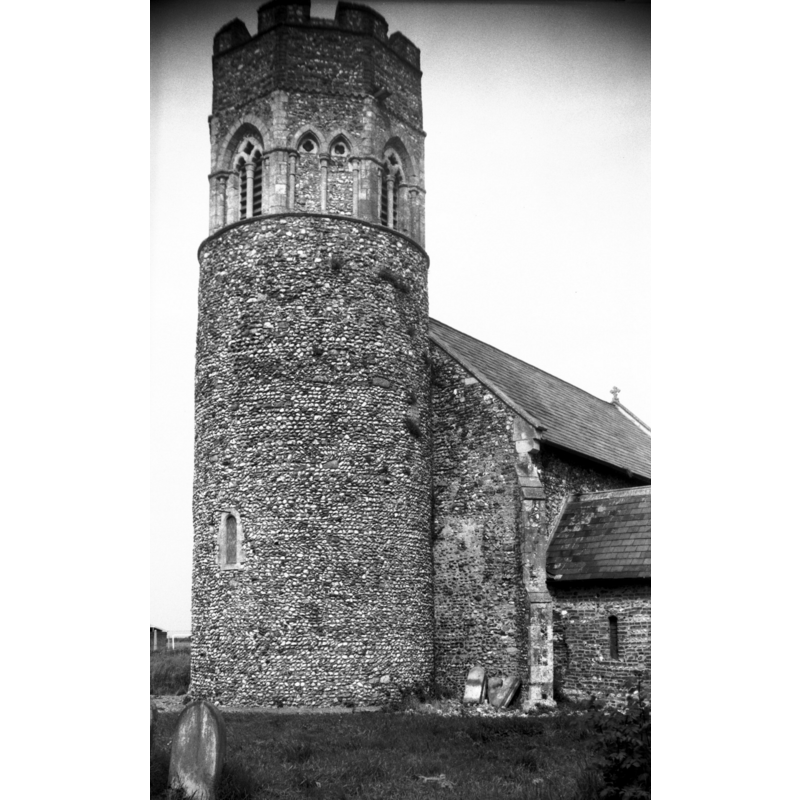 Photo caption: "The Norman round tower with 13c octagonal upper stage having double arcading and windows at cardinal points"