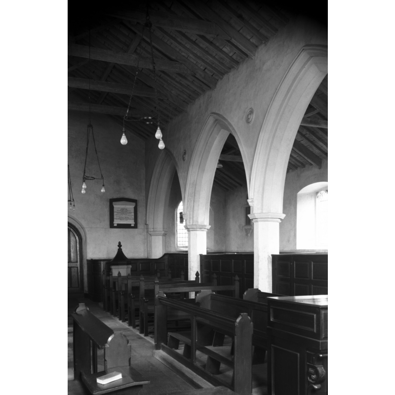 across the north arcade into the north aisle -- the font and cover are visible in the nave, to the right (north) of the tower door