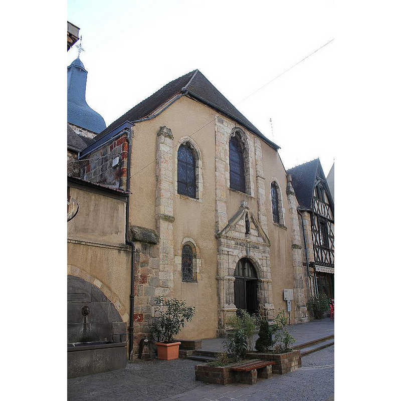 the 17th-century west façade at a northwest angle; the building is now sandwiched between attached buildings; on the left [north], a public fountain