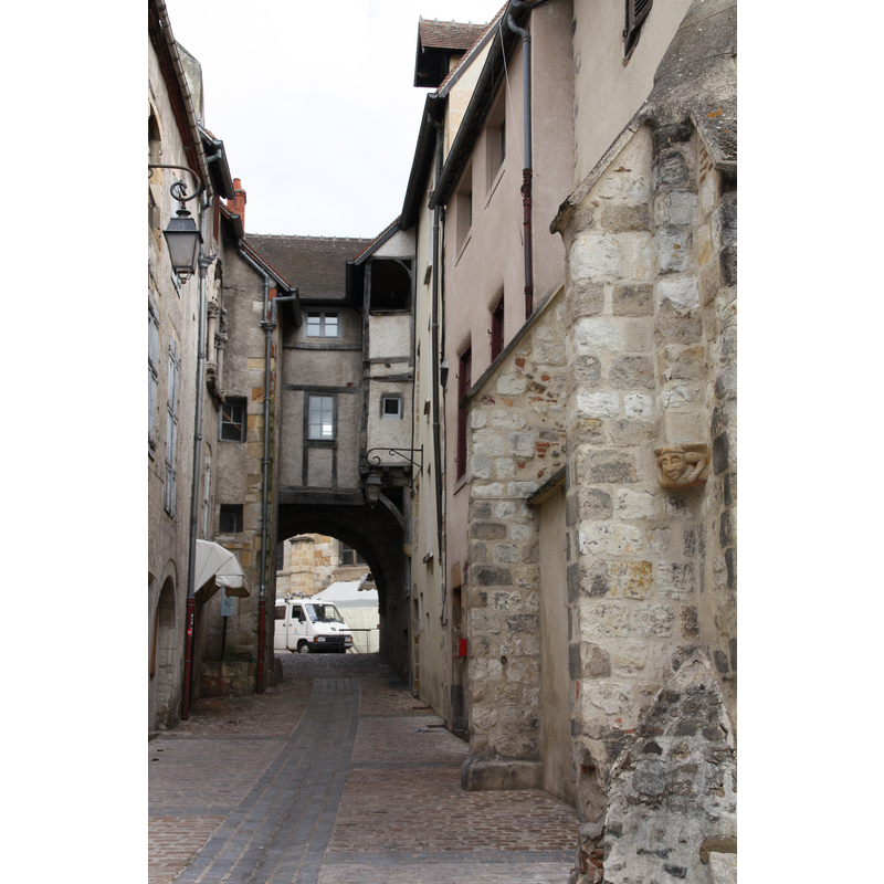 Photo caption: "Passage du doyenné à Montluçon" -- part of the old church is visible in the foreground, right side