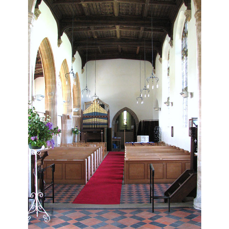 the upper part of the basin of the font is visible at the west end, behind the right [north] bank of benches