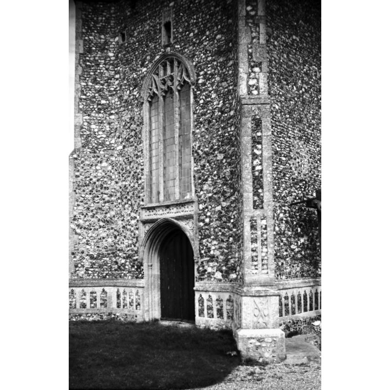 Photo caption: "West window with niche above. West doorway with quatrefoil frieze over. Flushwork panelled base"