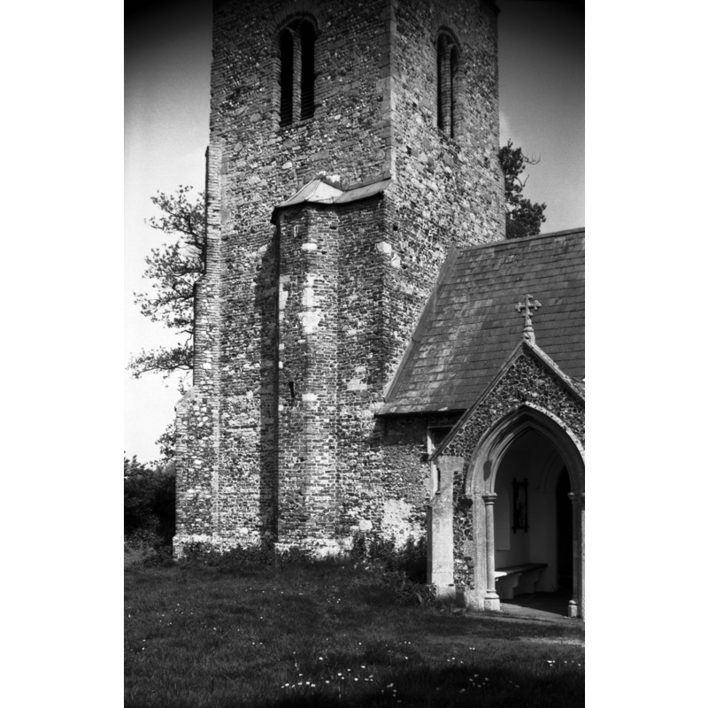 Photo caption: "South porch and stair turret to tower. Of flint with much brick trim"