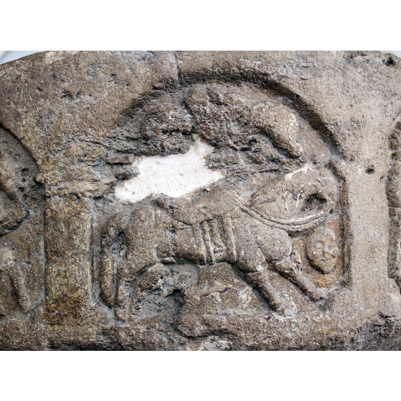 the horse is in a passant-to-the-right pose; there is damage and some carving missing above the horse's saddle, an area that looks very much like the horse by a tree, two arches to the left; there is a 'floating' human head or mask in the bottom right-hand corner, below the horse's head -- in the arch on the north side of the basin [NB: orientation is approximate]