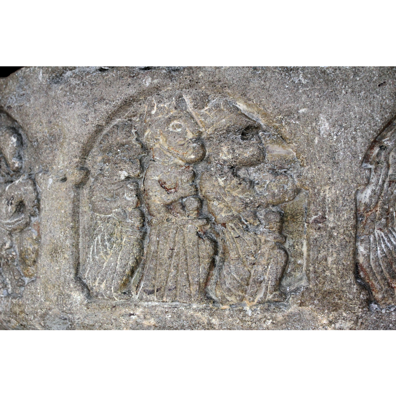 three figures on foot passant to the right, carrying objects in their right hands; left hands not visible; each wears (?) a sword; the two front figures are larger and wear crowns on their heads; the third figure is smaller and appears to wear a turban; the right knee of the first two figures is clearly visible and may be an indication that they are half-kneeling -- in the arch on the northwest of the basin [NB: orientation is approximate]
