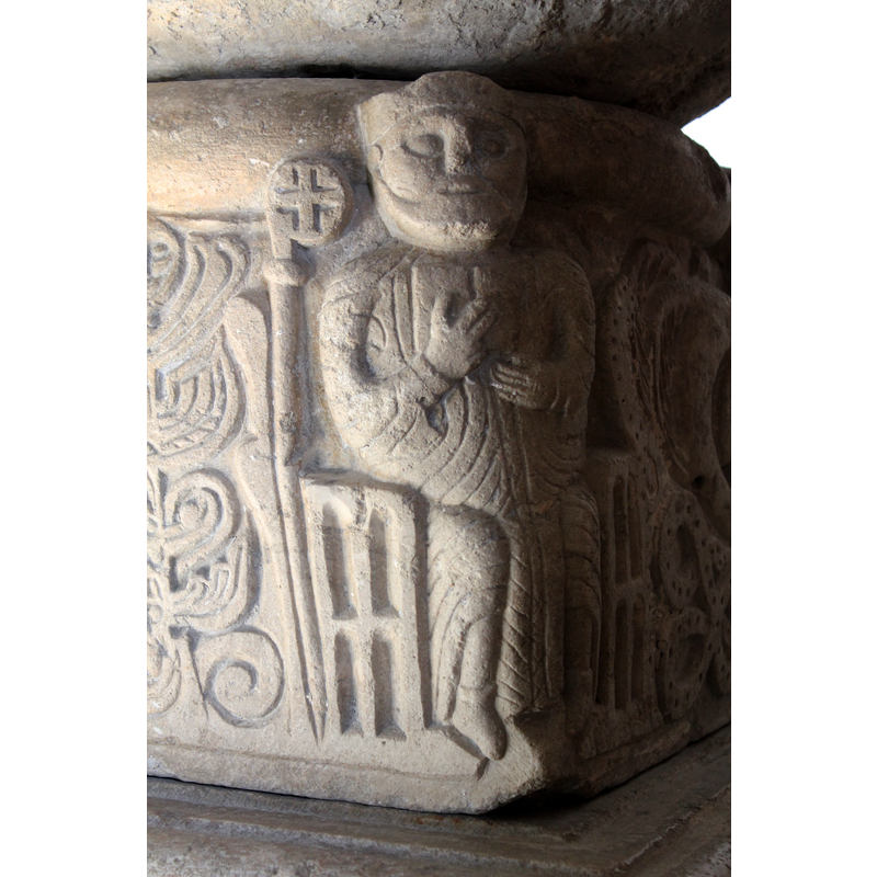 the staff is by the bearded bishop's right shoulder and not being held by him; the open book is held flat against his upper chest; the chair is carved, much like the others -- on the southeast corner of the base [NB: orientation is approximate]