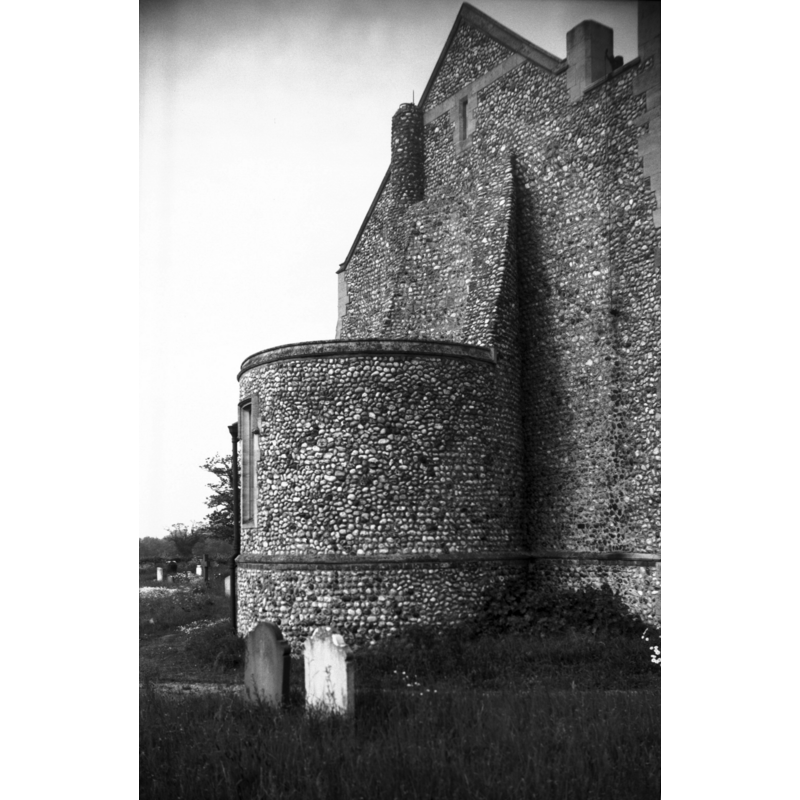 Photo caption: "Rebuilt in modern times, the church retains the base of the round tower. Used as a baptistry" [NB: the stump of the tower is actually 18th-century and nothing remains of the early-12th century original church here]
