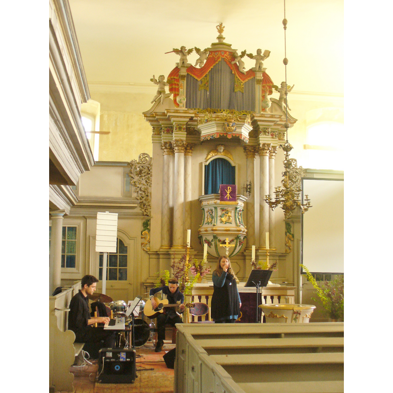 the top of the late-Baroque font is visible behind the pews