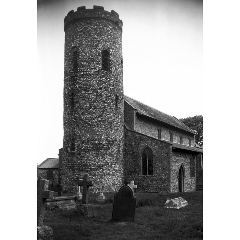 Photo caption: "Norman round tower is intact except for its later parapet"