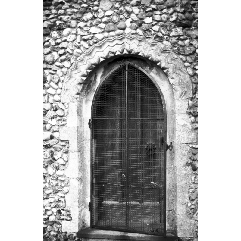 Photo caption: "Priest's door on south side of chancel with re-set Norman zigzag moulding"