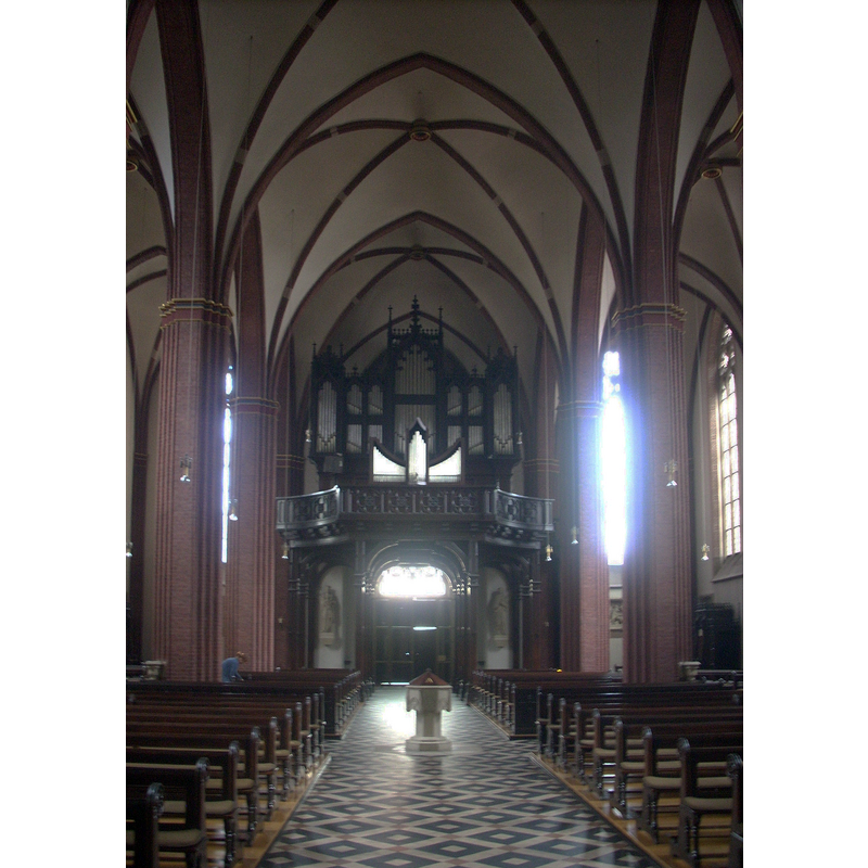 the baptismal font and cover stand in the centre of the aisle