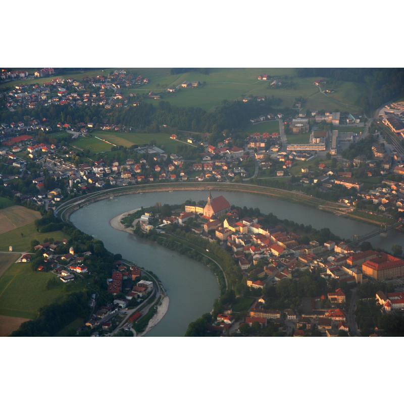 Photo caption: "The image shows the river Salzach, which forms the border between the German town of Laufen, Bavaria (below and right) and the Austrian town of Oberndorf bei Salzburg (above and left). The camera is pointing roughly northeast. The location of the Europa bridge (built 2007) is within the frame."  The collegiate church 'Mariä Himmelfahrt' is visible near the tip of the bend, on the German side.