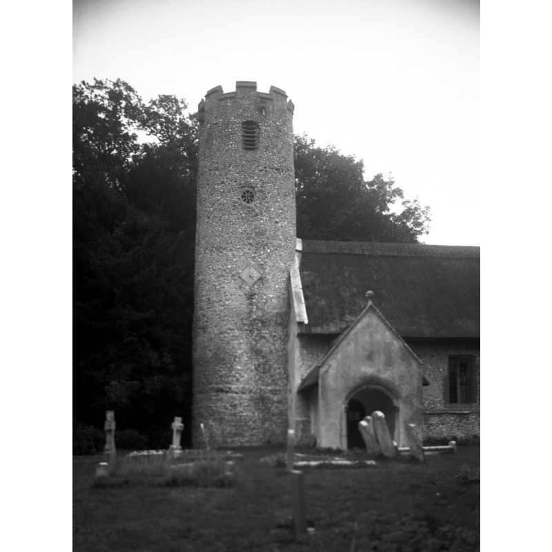 Photo caption: "The Anglo-Saxon round tower with circular windows having interlacing stonework"