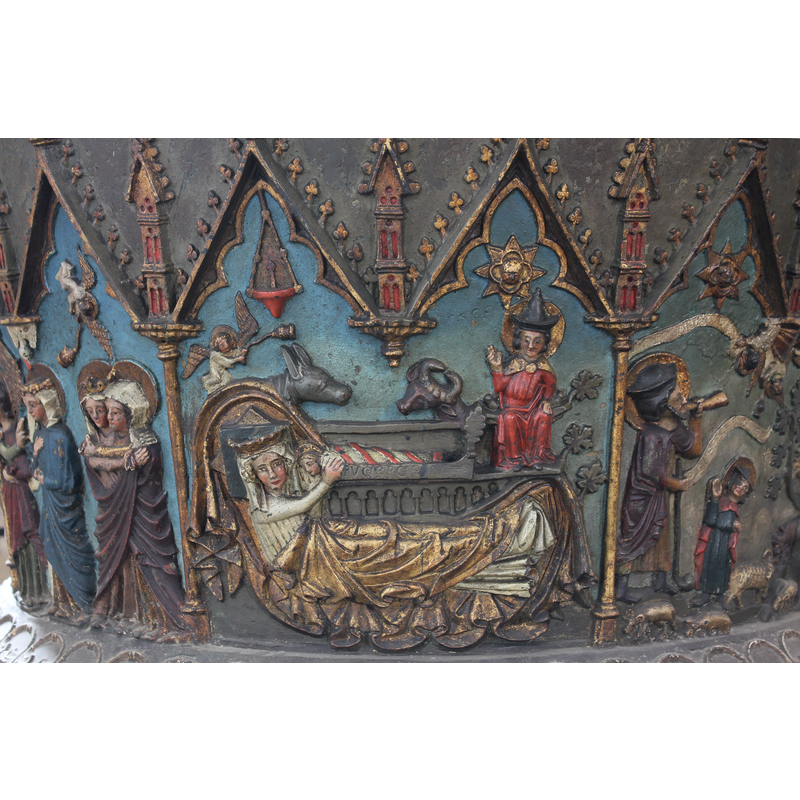 the Child is in the manger but Mary, lying in bed, embrace him and pull him towards her; Jew-hatted Joseph has right hand raised as in benediction; 8-pointed Sun has face in a quatrefoil; arcade on the bed side, which bears an inscription - the whole is framed in two arches of the arcade