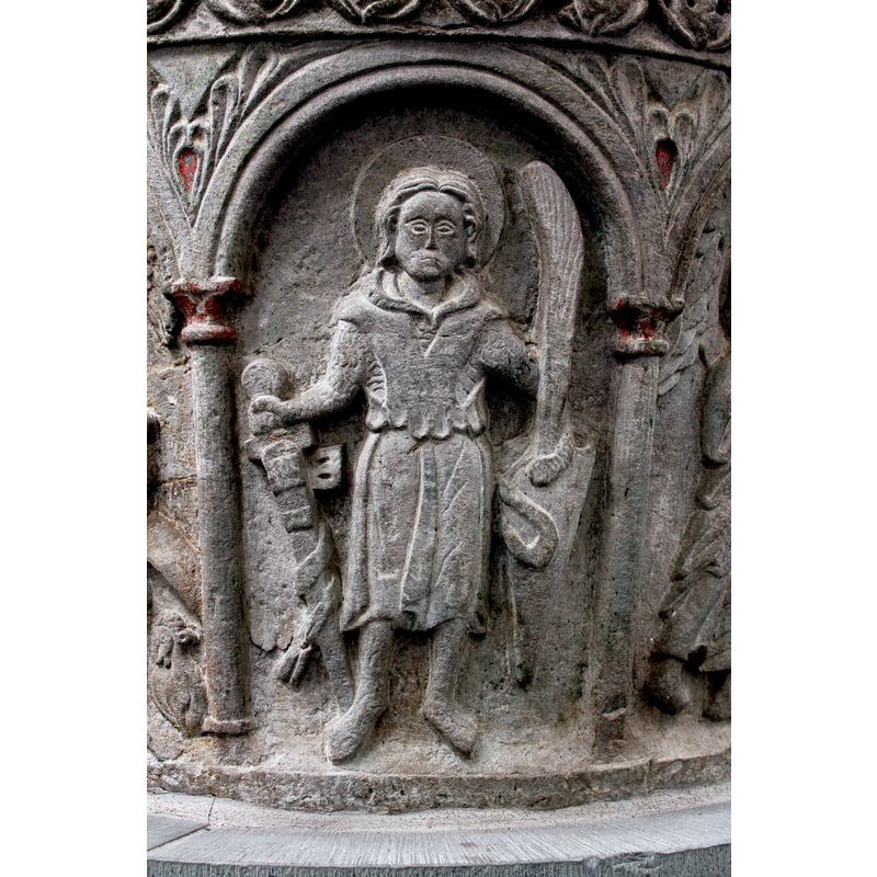 standing, haloed, holding a sword in his right hand, a feather in his left hand; lower on the left side is a shield with a serpent on its top