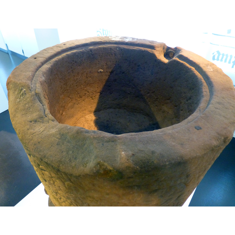 showing the two damaged areas; the one at the from obviously when the stone around the metal staple of the old cover; the indentation around the rim shows the font was originally designed to have a fitted cover