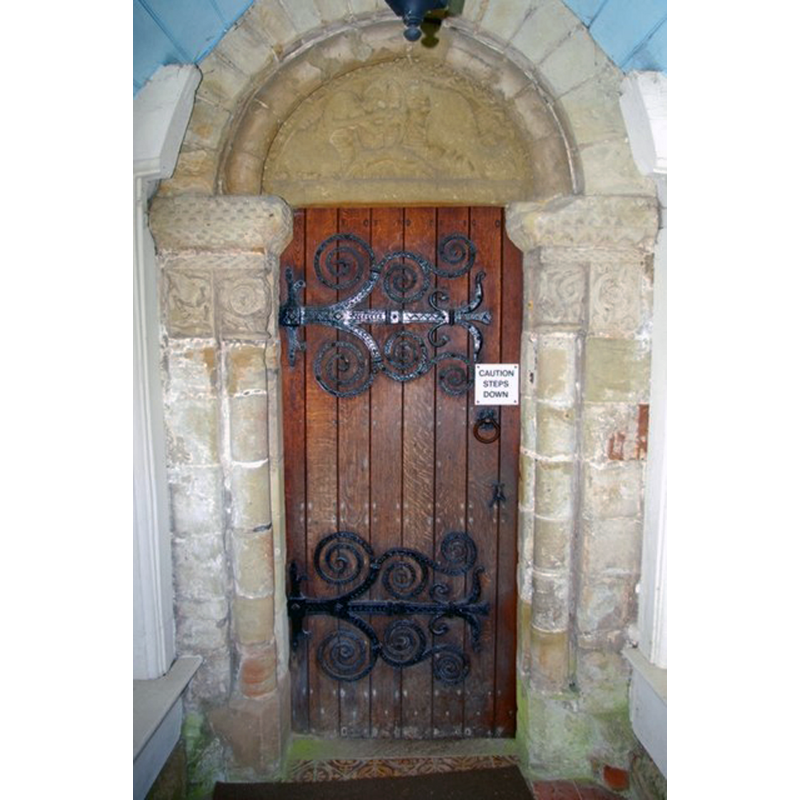 Source caption: "Pevsner wrote in 1968: "The north doorway has very involved capitals with beaded interlace. To the left is a panel with a bird (a Herefordshire motif). The abaci have chequer and zigzag patterns, the arch a roll moulding. Tympanum with an archer and two quadrupeds.""