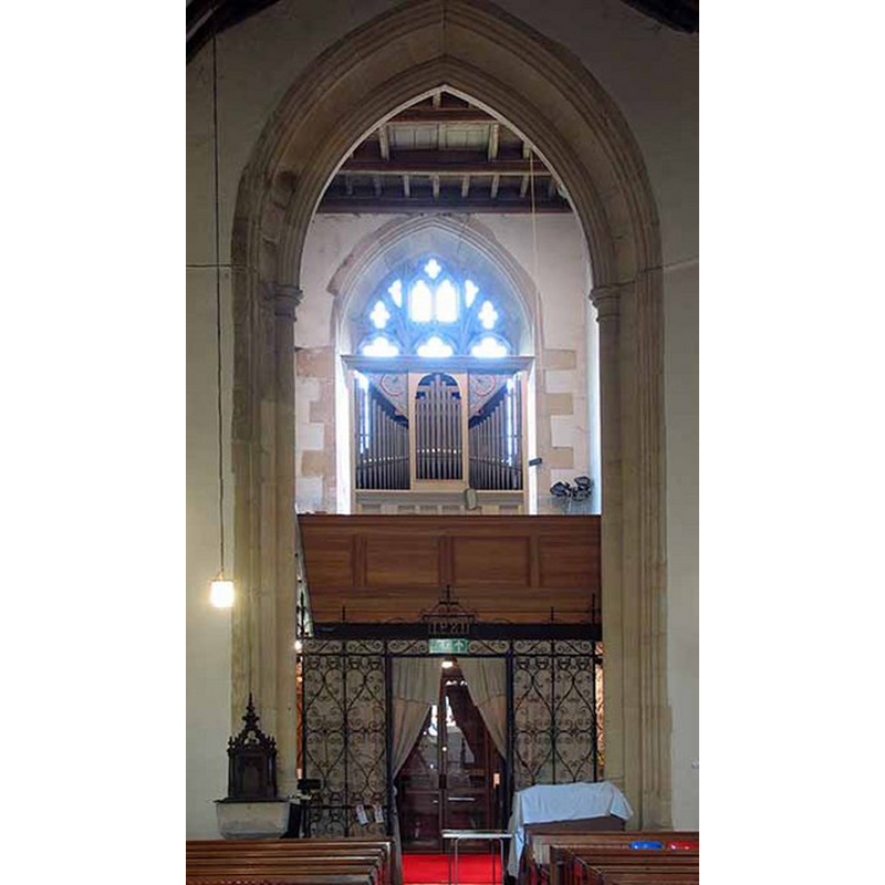 at the west end of the nave, by the left [south] pillar of the tower arch