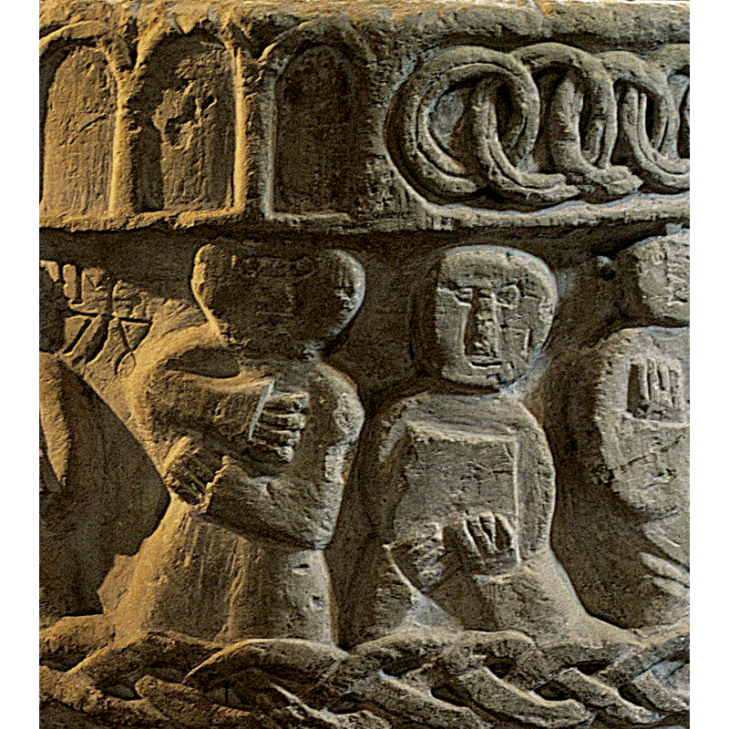 a figure standing, frontal, holding hands across his chest. To the right follows a figure holding a book with both hands -- on the northeast side of the basin [NB: orientation is approximate]