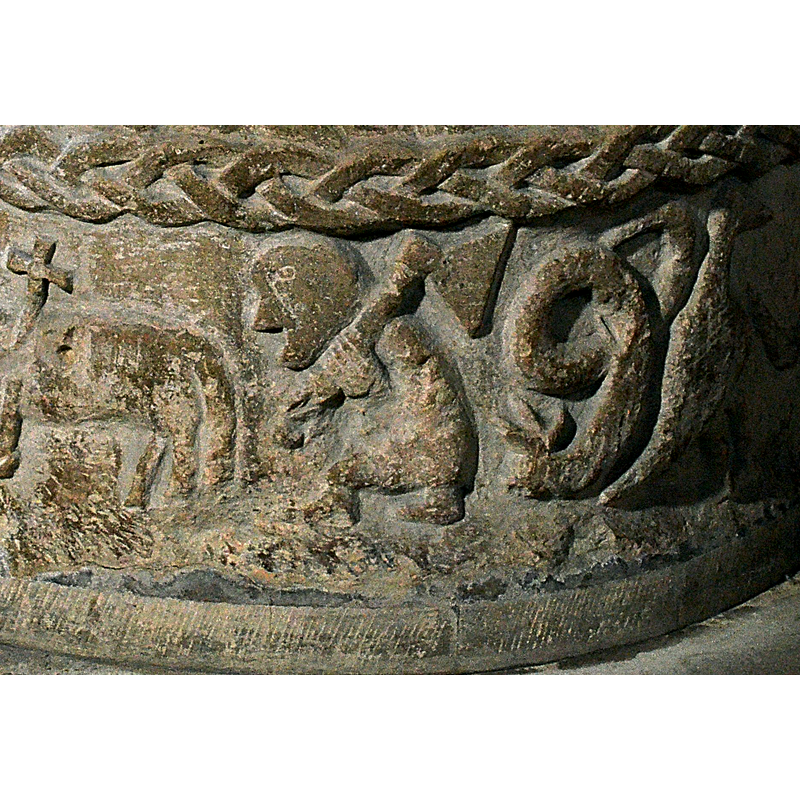Lower Register. To the right of Agnus Dei, a figure carries a large axe on his shoulder. To the right, a serpent, back to back with a bird. The serpent faces left and bird faces right -- on the southeast side of the basin [NB: orientation is approximate]