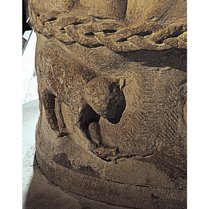 Lower Register. A lion faces right and holds something in his front paws - a snake? -- on the east side of the basin, approximately below the baptismal scene [NB: orientation is approximate]