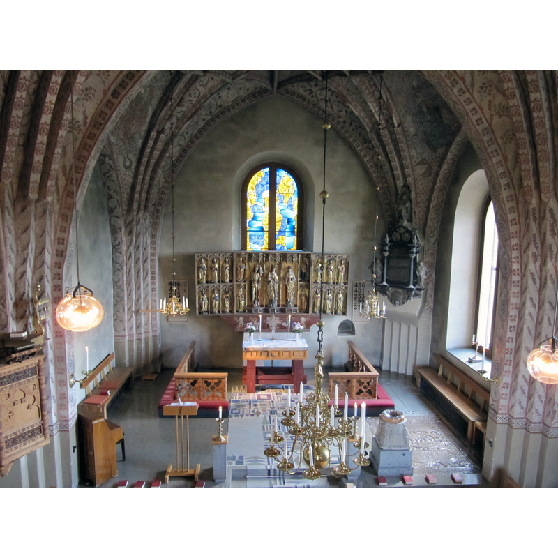 the remaining base of the old baptismal font, mounted on a low pedestal, and supporting a baptismal dish, is visible in the foreground, by the right [south] side of the chancel arch