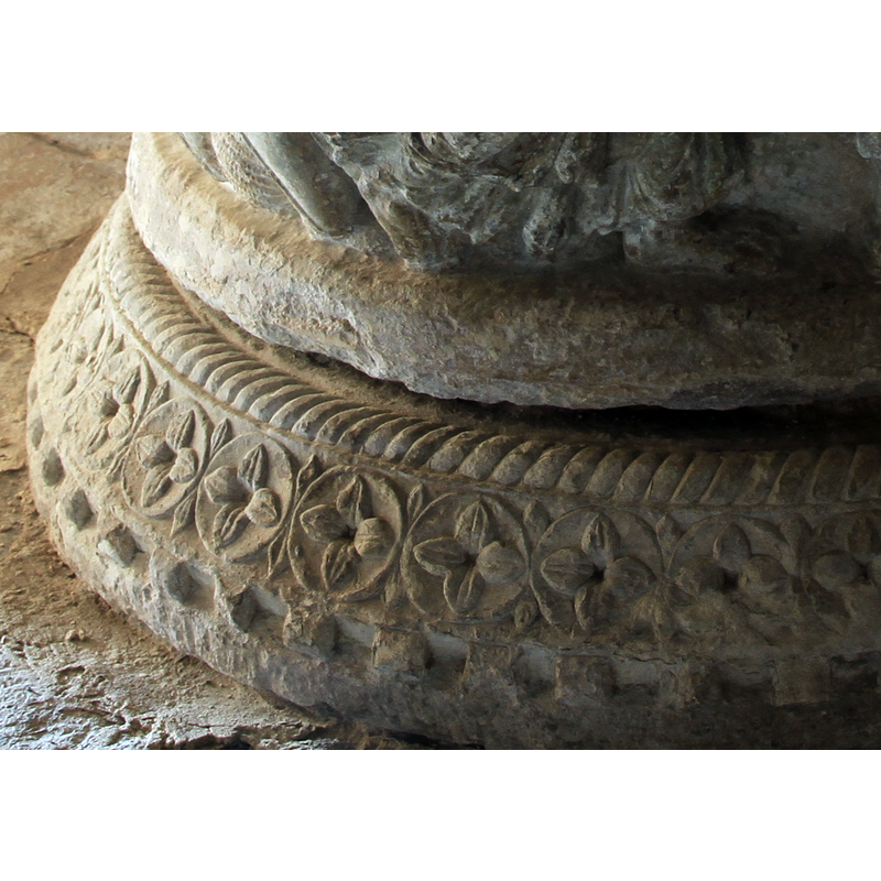 a band all around the middle of the lower base section, with petals or beads in the spandrels of the circles