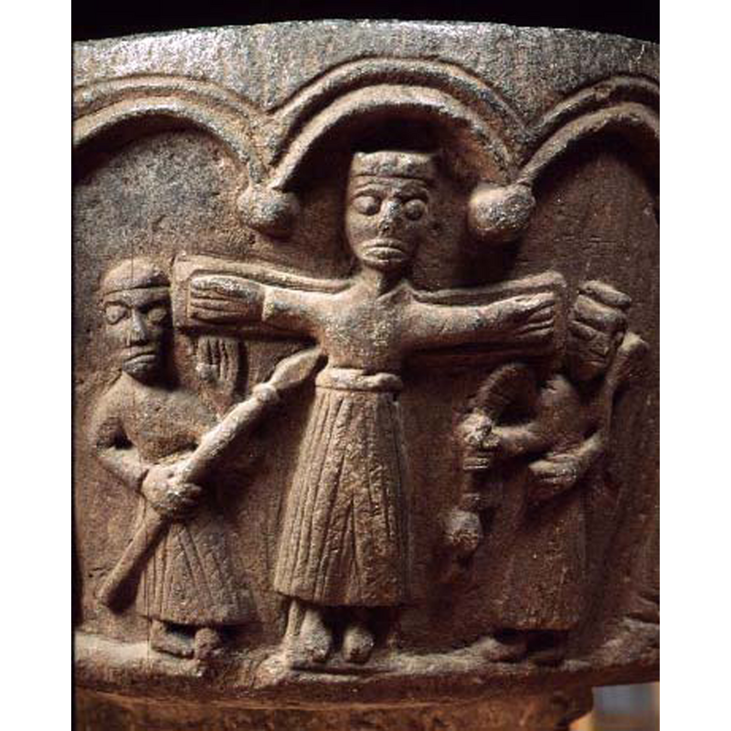 Christ on the cross; no halo; crown-like hair (?); body covered from the neck; long sleeves; long skirt to the showing feet; standing figure (Longinus?) on the left. poining a lance to Christ's chest side, left hand raised with palm outwards; by the right arm of the cross is a standing angel holding what appears to be a censer