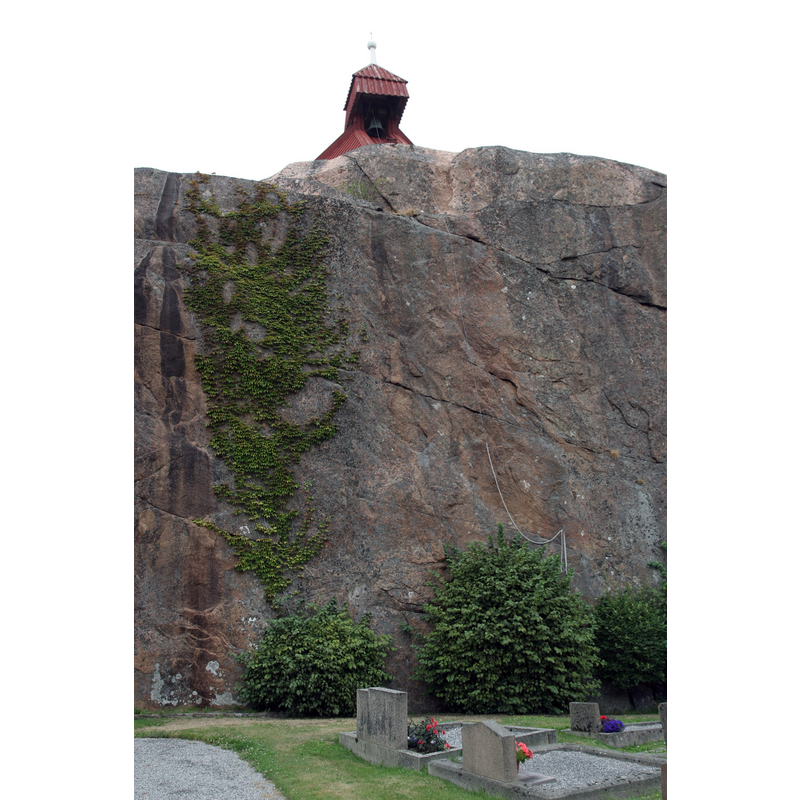 the bell-ringing ropes can be seen hanging towards the right, down the side of the rock face