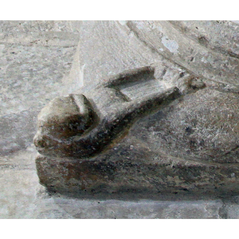 four of them, one at each end of the square end of the lower base; the look like human demi-figures, facing the font, their arms extended and the hands holding to one of the roundels of the lower base