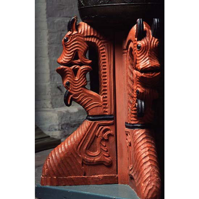 a striking arrangement on the cruciform base; the upper head has a long neck but no apparent body, while the lower head is attached to a rampant upper body