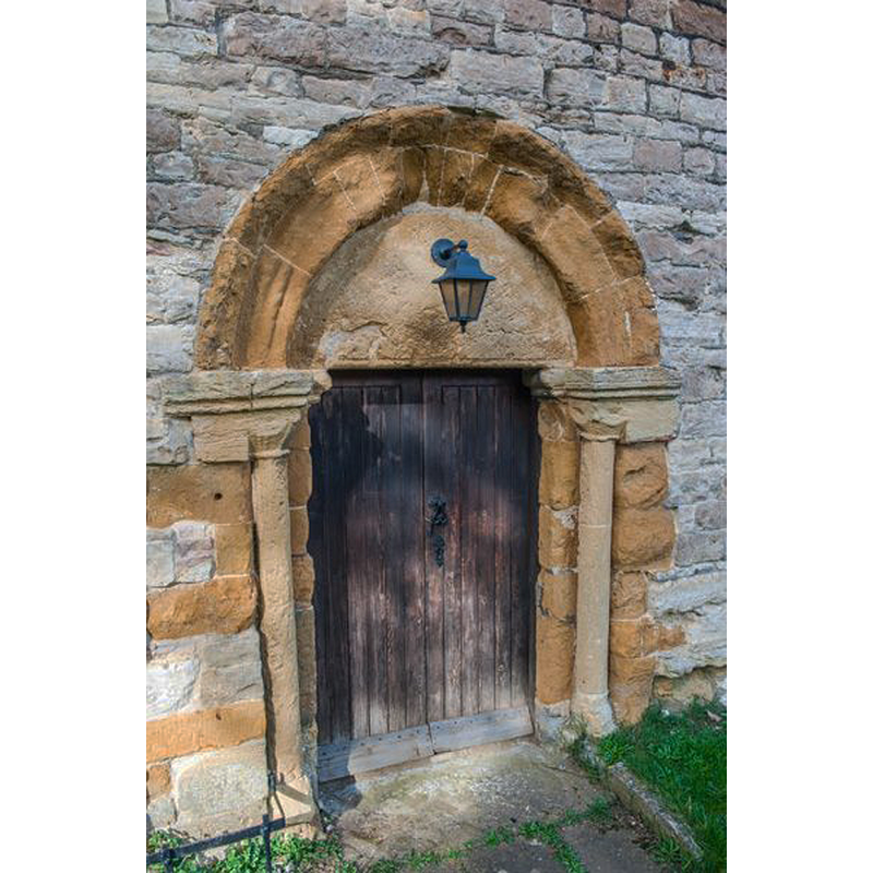 Source caption: "Norman north doorway with carved tympanum and capitals."