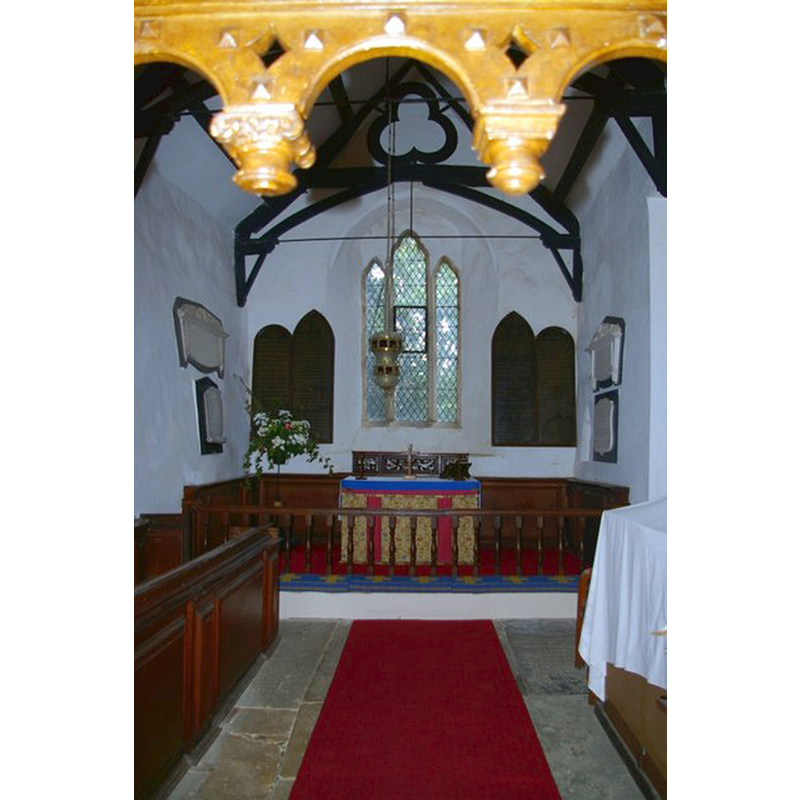 Source caption: "Chancel of St James the Great Church. Seen beneath the pendants of a Jacobean screen, the altar is flanked by boards inscribed with the Lord's Prayer, Creed and Commandments and enclosed by 18th-century communion rails. In front of it is a hanging pyx. The 13th-century north wall leans visibly outwards under the weight of the roof."
