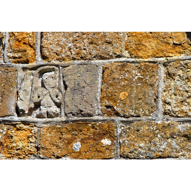 Source caption: "Sheela-na-gig. This ancient carved stone, set in the porch of James Fowler's 1862 church, is not mentioned in Pevsner, though he does mention stone fragments, including one from Bardney Abbey."
